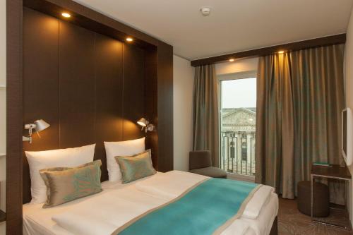 ein Schlafzimmer mit einem großen Bett und einem großen Fenster in der Unterkunft Motel One Berlin-Potsdamer Platz in Berlin