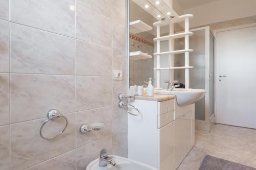 ein Bad mit einer Dusche, einem Waschbecken und einem Spiegel in der Unterkunft Mila Apartments Brizi in Mailand