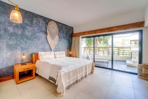 a bedroom with a bed and a large window at Aldea Thai Beachfront Condo Complex with Resort Pool & Amenities in Playa del Carmen
