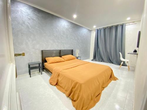 a bedroom with a bed with an orange blanket at Bel appartement avec une belle vue sur la grande mosquée Hassan II et la mer in Casablanca