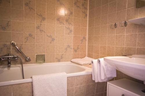 a bathroom with a bath tub and a sink at Apartmenthaus Frauenpreis FeWo 205 in Cuxhaven
