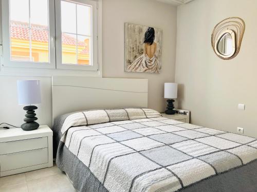1 dormitorio con 1 cama, 2 lámparas y una pintura en Ático de lujo - Luxury Penthouse en Huelva