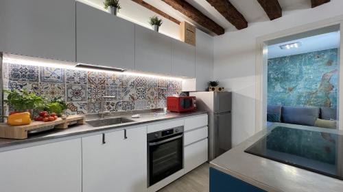 a kitchen with white cabinets and a sink and a refrigerator at Residence Stella in Venice
