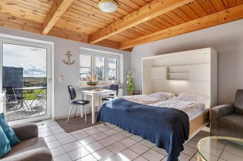una camera da letto con un letto, un tavolo e delle sedie di Schipp Landen Lisa a Schobüll
