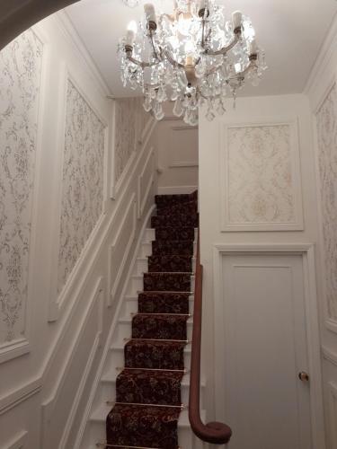 a chandelier in a hallway with a staircase at Westend in Ryde