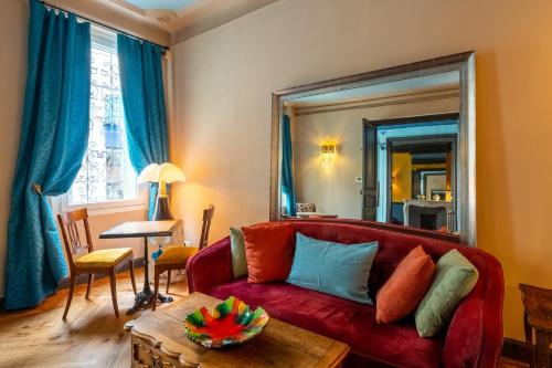 a living room with a red couch and a table at La Maison d'été in Salon-de-Provence