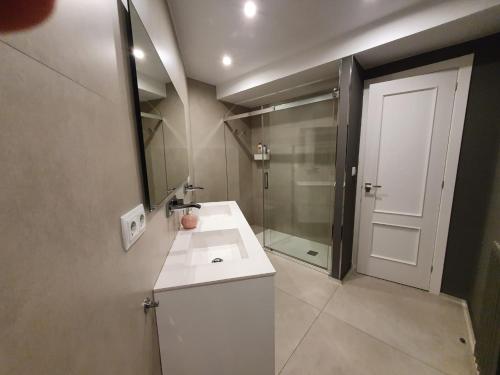 uma casa de banho com um lavatório, um espelho e um chuveiro em Magnifico piso centro ciudad em La Coruña