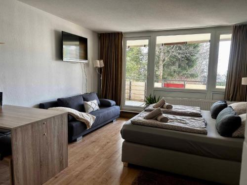 a living room with a blue couch and a table at Bergerlebnis Natur pur in Sankt Englmar