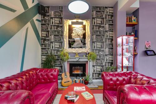a living room with two red leather couches and a fireplace at Clink261 Hostel in London