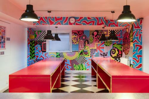 a restaurant with graffiti on the wall and two tables at Clink261 Hostel in London