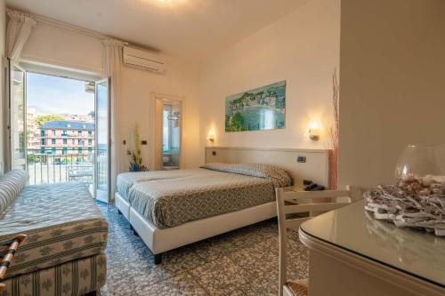 a hotel room with a bed and a balcony at Hotel Riviera in Deiva Marina