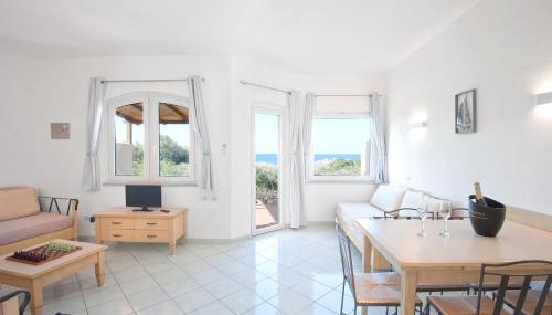 a living room with a couch and a table at Calarossa Bay in Isola Rossa