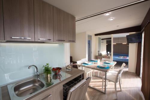 a kitchen with a sink and a table with a dining room at La Rocca Camping Village in Bardolino