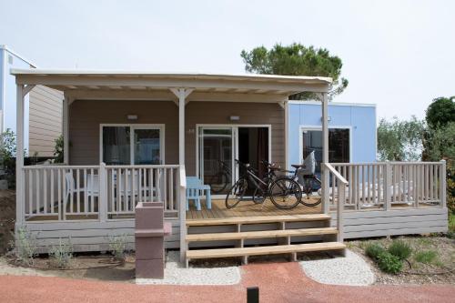 a tiny house with a porch and bikes on the deck at La Rocca Camping Village in Bardolino