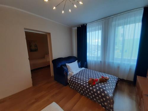 um quarto com um urso de peluche sentado numa cama em Apartment Central Park em Daugavpils