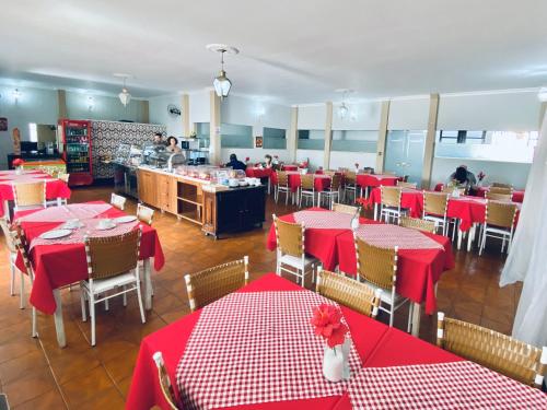 a restaurant with red and white tables and chairs at Hotel Real São Lourenço in São Lourenço