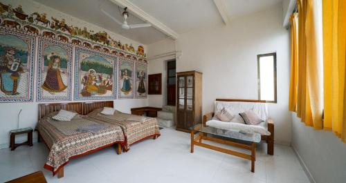 a bedroom with a bed and a couch and a chair at Tourist Pension in Nawalgarh