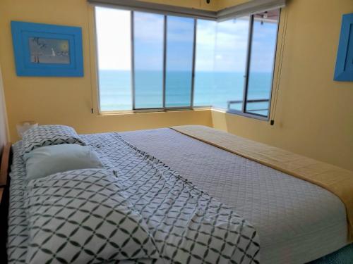 een slaapkamer met een bed en uitzicht op de oceaan bij Pelican View & Sunsets! in Bahía de Caráquez