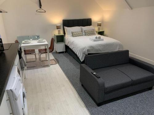 a bedroom with a bed and a chair and a table at Guest Homes - Eign Street Apartments in Hereford