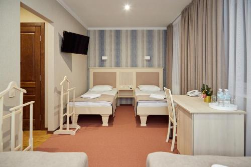 una habitación de hospital con 3 camas y una mesa en Hotel Korona, en Mostiska