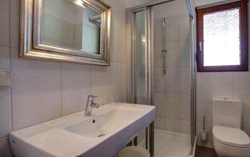 ein Badezimmer mit Waschbecken, Toilette und Spiegel in der Unterkunft Garni-Hotel Kranich in Potsdam