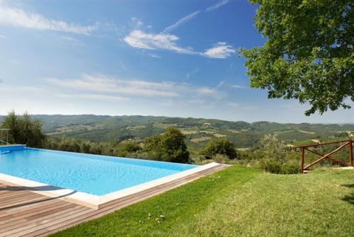 a swimming pool in a yard with a view of the mountains at Renzo Marinai in Panzano