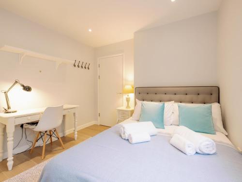 a bedroom with a bed with a desk and a desk at Pass the Keys Stylish Home - Prime Location in London