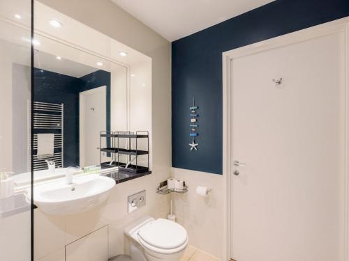 a bathroom with a white toilet and a sink at Pass the Keys Stylish Home - Prime Location in London