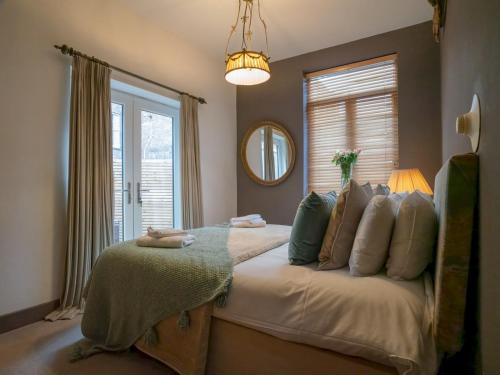a bedroom with a large bed with a window at Pass the Keys Montpellier mews home with parking and garden in Cheltenham