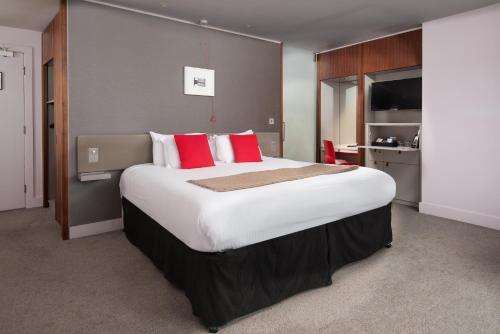 a large bed in a hotel room with red pillows at The Midland in Morecambe