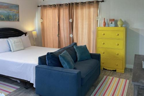 a bedroom with a bed and a couch and a dresser at Sunnyside Studio in Panama City Beach