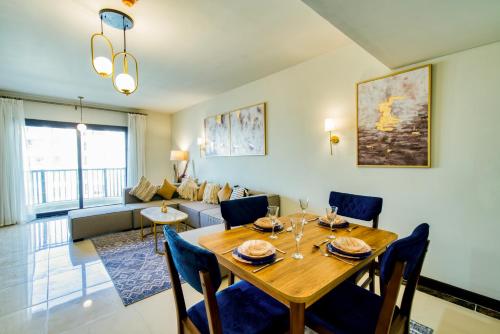 a dining room and living room with a table and chairs at LOFTS by Elegant Hospitality in Cairo