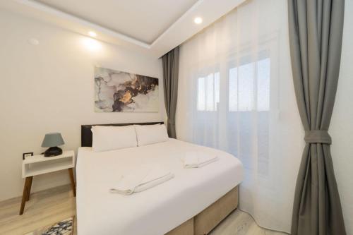 Habitación blanca con cama y ventana en Char, en Antalya