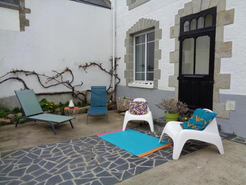 - un ensemble de chaises assises sur une terrasse dans l'établissement la maison blanche, à Cléden-Cap-Sizun