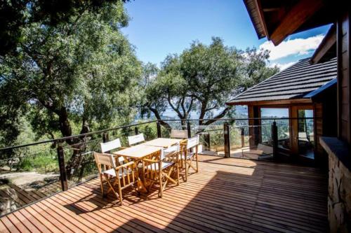 una terraza de madera con mesa y sillas. en Casa Karine - Vue imprenable et dolce vita en San Carlos de Bariloche