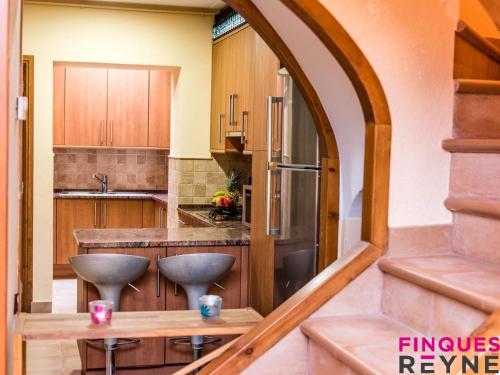 an arched doorway into a kitchen with wooden cabinets at Casa Monestir in Sant Feliu de Guíxols
