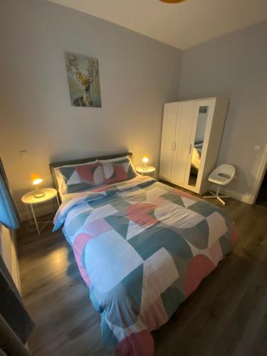 een slaapkamer met een groot bed en een kleurrijk dekbed bij Modern and spacious city centre apartment in Dublin