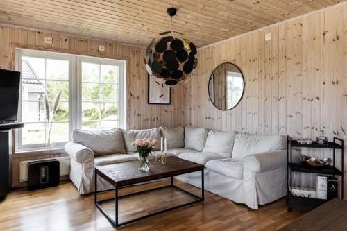Nice house near golf and skiing في Hestra: غرفة معيشة مع أريكة بيضاء وطاولة