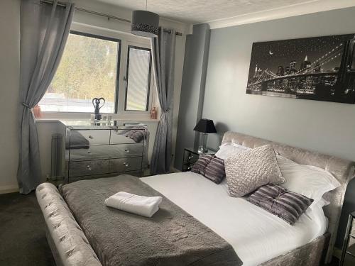 een slaapkamer met een bed, een wastafel en een raam bij The Brook House - Spacious 3 Bed Home From Home in Burton upon Trent