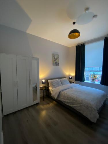 een slaapkamer met een groot bed en een groot raam bij Modern and spacious city centre apartment in Dublin