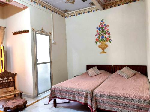 a bedroom with two beds and a christmas tree on the wall at Tourist Pension in Nawalgarh