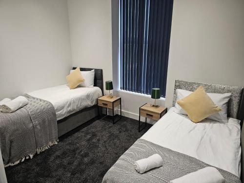 a hotel room with two beds and a window at Skyline Remarkable 2-Bed Apartment in Swansea in Swansea