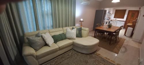 - un salon avec un canapé et une table à manger dans l'établissement Forest View Cottage, à Pietermaritzburg