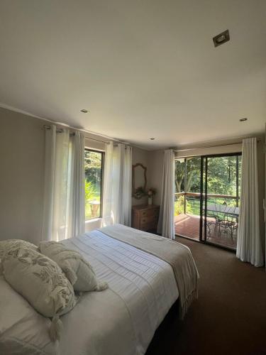 a bedroom with a large bed and a large window at Forest View Cottage in Pietermaritzburg