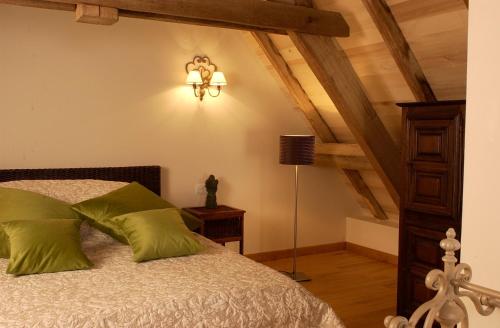 een slaapkamer met een bed met groene kussens bij Maison de famille in Camboulit