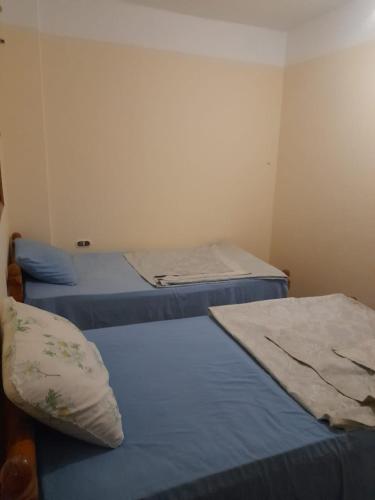 two beds in a small room with blue sheets at Elbadawy camp in Nuweiba