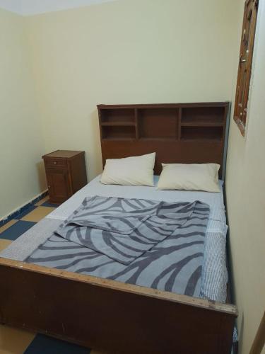 a bed in a room with a wooden head board at Elbadawy camp in Nuweiba