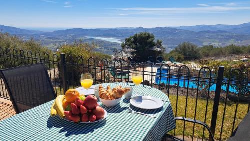 a table with a bowl of fruit and glasses of wine at Cantueso Holiday Park in Periana