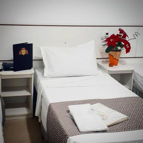 a hotel room with two beds and a plant at HOTEL CUCA FRESCA - COTIA in Cotia