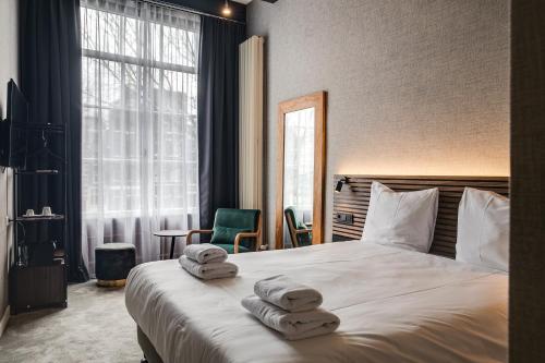 a hotel room with a bed with towels on it at The Sixteen in Amsterdam